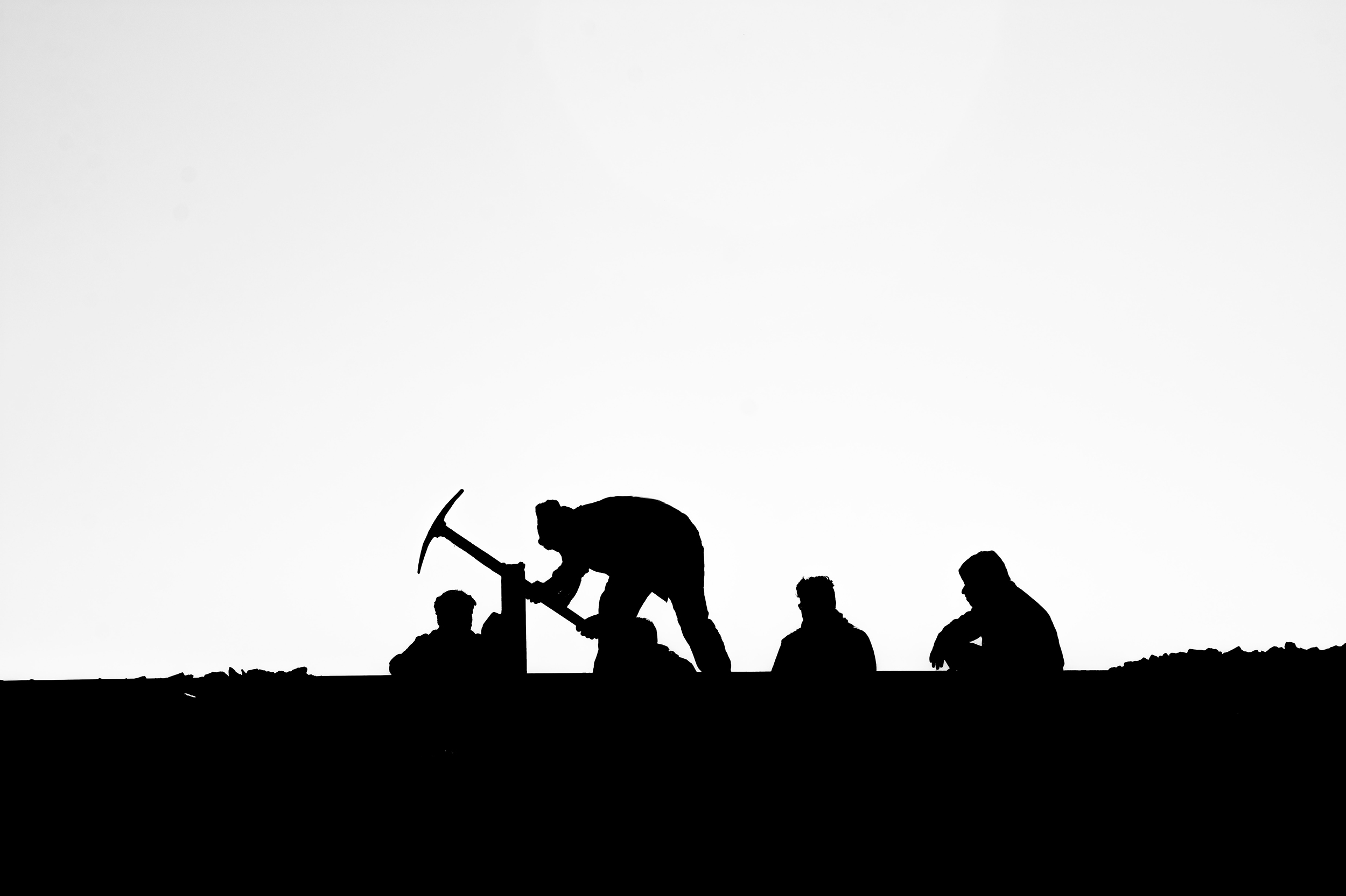 Black and white photo of men digging.